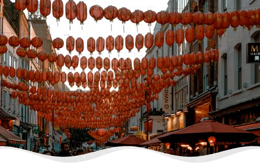 Red Chinese lanterns hanging over a busy street in Chinatown, London