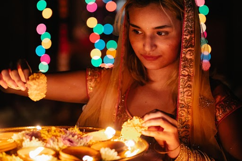 Woman with lit diyas celebrating Diwali