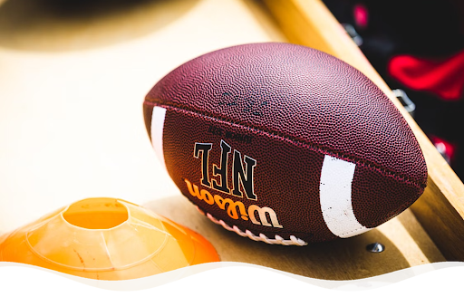 Wilson NFL American football next to an orange training cone, for an NFL event listing in London