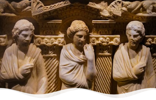 Three carved marble figures in robes between spiral columns on an ancient Roman stone relief